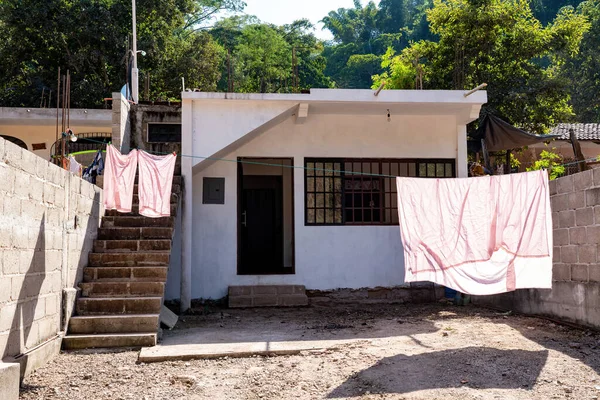 run down small white house in rural Puerto Vallarta with laundry out to dry on closeline