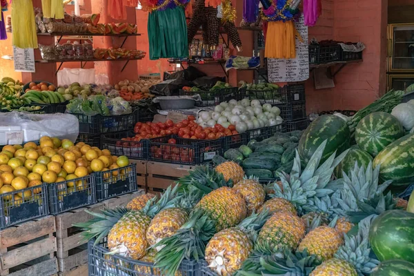 in-store view of a small fruits and vegetables store with colorful pinatas hanging throughout 