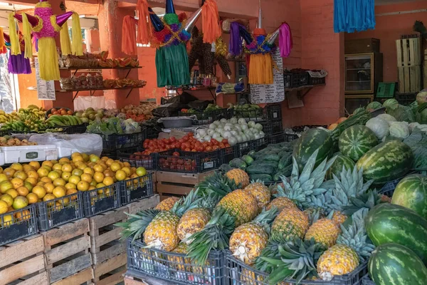 in-store view of a small fruits and vegetables store with colorful pinatas hanging throughout 