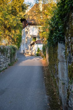 Talloires, Fransa - Eylül 08 2020: Fransız dağlarında sarmaşıklarla kaplı tarihi bir eve giden küçük bir yol