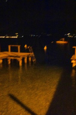 Menthon Aziz Bernard, Fransa - 14 Eylül 2020: Kristal berrak suyun üzerinde, su yüzeyinde yansımaları olan ahşap bir iskele