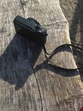 Wassenaar, Hollanda - 06 Kasım 2020: Ahşap bir bankın üzerine siyah bir fotoğraf makinesi yerleştirildi