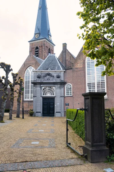 Voorburg, Hollanda - 04 Mayıs 2021: Kulesiyle tarihi bir Dini Hollandalı kilise binasının giriş yolu