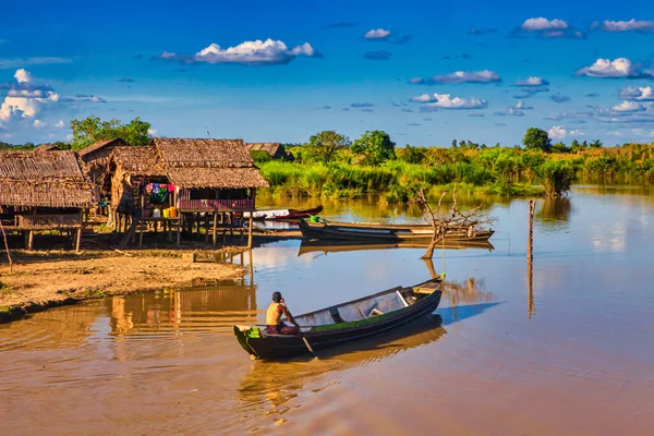Bago, Myanmar - 02 Aralık 2012: Geleneksel Myanmar bambu kırsal evi ya da kırsal kesimde nehir ve uzun kuyruklu teknelerin bulunduğu cambaz ayaklıkları üzerindeki kulübe