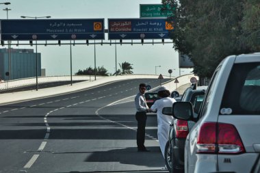 Doha, Katar - 27 Ocak 2010: Terk edilmiş otoyolun ortasında iki araba sürücüsü durdu ve sohbet ettiler