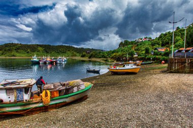 Castro, Şili - 08 Kasım 2014: Renkli Castro Chiloe ahşap evleri ve karada uzanan bir tekne manzarası