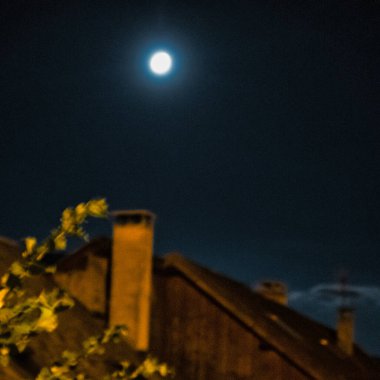 Menthon Aziz Bernard, Fransa - Eylül 01 2020: Ortaçağ kırsal binasının çatısında dolunay parlıyor