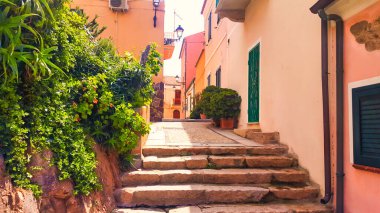 La Maddalena, İtalya - 4 Nisan 2016: Sardunya adasındaki bir köyde tarihi İtalyan evleri arasında adımları olan küçük, huzurlu bir ara sokak