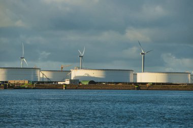 Rotterdam, Hollanda - 22 Kasım 2021: Yeşil ve fosil enerji, rüzgar türbinleri ve fosil yakıtların bir kombinasyonu