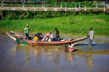 Yangon, Myanmar - 03 Aralık 2012: Gündüz vakti Yangon Myanmar nehrinde uzun kuyruklu bir tekneyle birçok insanın taşınması