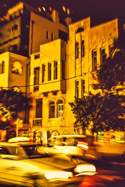 イスラエルのテルアビブ 2010年11月11日 テルアビブの夜のバウハウス植民地時代のオフィスビルタクシーが通りを通って忙しい通りで — ストック写真