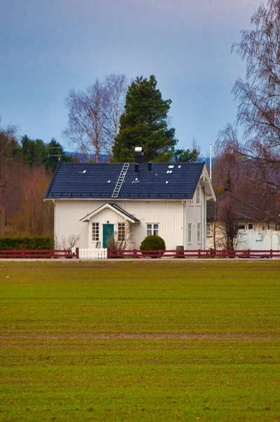 ノルウェーのオスロ2012年4月25日 田舎の緑の畑で 白い典型的な家と濃い青の屋根 — ストック写真
