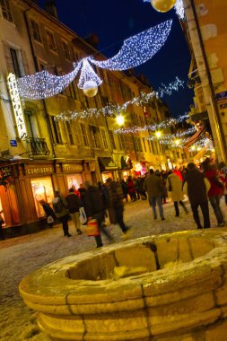 Annecy, Fransa - 18 Aralık 2010: Karlı kış mevsiminde, Orta Çağ Annecy 'de ana alışveriş caddesinde birçok kişi Noel süslemeleri ile birlikte