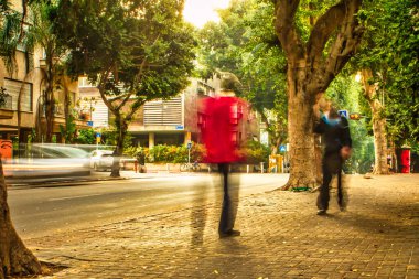Tel Aviv, İsrail - 11 Kasım 2010: Birkaç kişi Tel Aviv kaldırımında gündüz vakti yürürken tamamen hareketli bir şekilde bulanıklaştı
