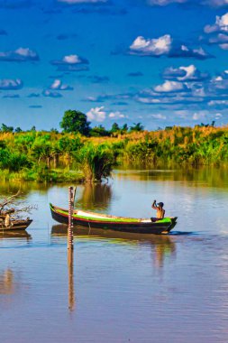 Bago, Myanmar - 02 Aralık 2012: Geleneksel Myanmar bambu kırsal evi ya da kırsal kesimde nehir ve uzun kuyruklu teknelerin bulunduğu cambaz ayaklıkları üzerindeki kulübe