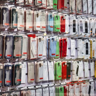 Lahey, Hollanda - 03 Ocak 2022: Bir telekomünikasyon mağazasının duvarında asılı duran telefon kılıfları akıllı bir telefon için her türlü ürünü satıyor.