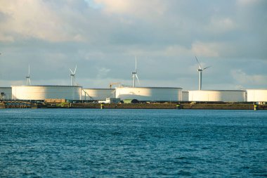 Rotterdam, Hollanda - 22 Kasım 2021: Yeşil ve fosil enerji, rüzgar türbinleri ve fosil yakıtların bir kombinasyonu