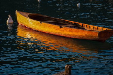 Talloires, Fransa - 08 Eylül 2020: tarihi eski bir ahşap tekne limanda yüzüyor ve limana yanaşıyor.