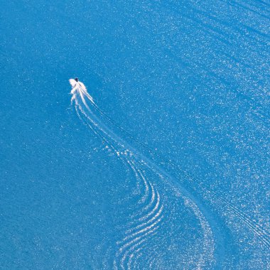 Talloires, Fransa - Eylül 08 2020: Hızlı giden bir sürat teknesinin hava görüntüsü ve arkasında dalgalar var