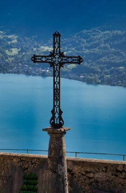 Talloires, Fransa - Eylül 08 2020: Saint Germain kilisesinin devasa demir haçı Annecy Gölü ve dağlarına bakıyor.