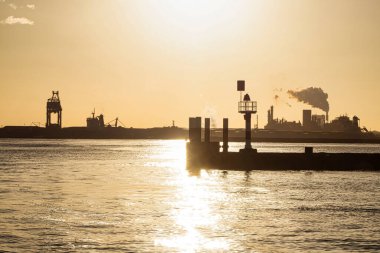 Rotterdam, Hollanda - 22 Kasım 2021: Gün batımında parlayan bir ışıkla birlikte bir liman başı