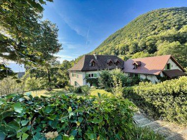 Menthon Aziz Bernard, Fransa - Eylül 07 2021: Annecy Gölü manzaralı Alplerin yuvarlanan tepelerinde zarif bir Fransız konağı