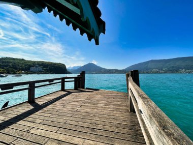 Menthon Aziz Bernard, Fransa - 12 Eylül 2021: Limandaki turist teknesinin rıhtımı veya iskelesi geniş panoramik manzaralı ilhak gölü manzaralı.