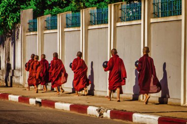 Yangon, Myanmar - 02 Aralık 2012: Genç Budist rahipler, Myanmar 'daki yemek teklifleri için ellerinde kaseyle uzun bir sıra oluşturdular.