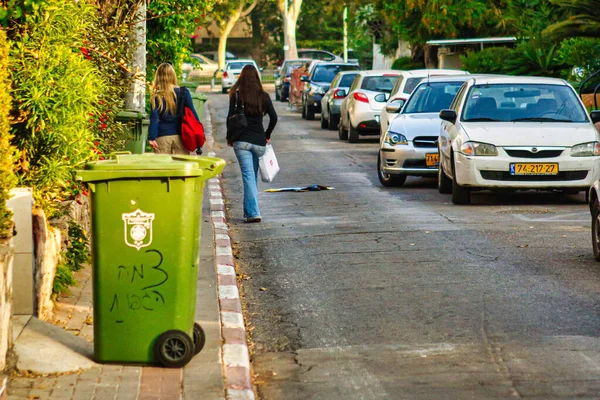 Tel Aviv, İsrail - 11 Kasım 2010: Tel Aviv 'de tahsilata hazır bir yerleşim sokağındaki kaldırımın kenarında yeşil bir konteyner duruyor.