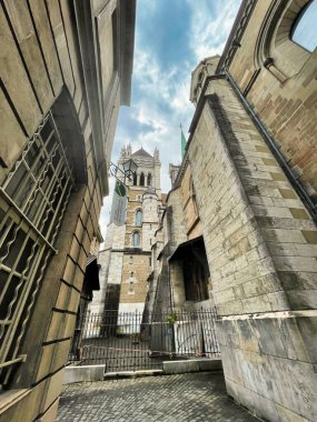 Cenevre, İsviçre - 15 Eylül 2021: tarihi çan kulesi manzaralı çok küçük bir ortaçağ sokağı manzarası