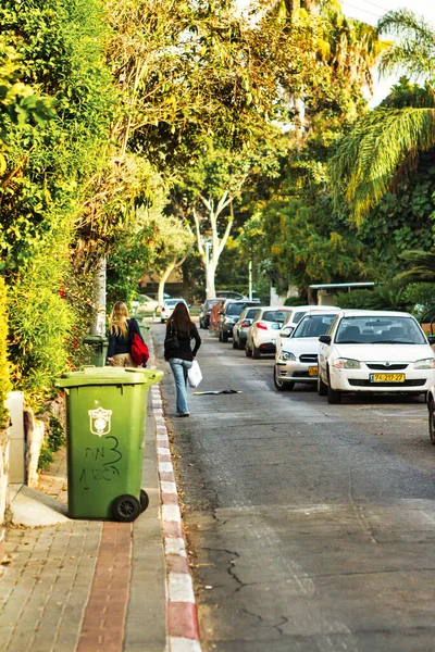 Tel Aviv, İsrail - 11 Kasım 2010: Tel Aviv 'de tahsilata hazır bir yerleşim sokağındaki kaldırımın kenarında yeşil bir konteyner duruyor.