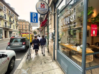 Cenevre, İsviçre - 15 Eylül 2021: Bir Tayland restoranının ön camından geçen iki kişi
