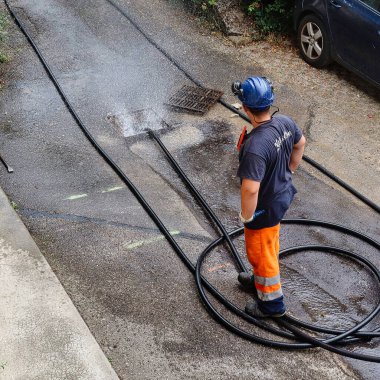 Menthon Saint Bernard, Fransa - 09 Eylül 2021: profesyonel bir işçi kanalizasyon borusunu temizlerken pompalı araba ve yüksek basınçlı hortumla meşgul