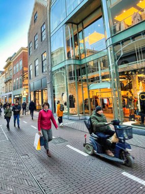 Lahey, Hollanda - 16 Aralık 2021: Kentin tarihi bir alışveriş caddesinde birçok kişi alışveriş çantalarıyla yürüyor