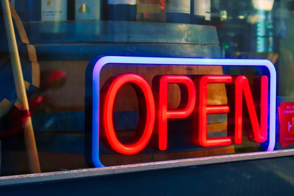 Den Haag, Hollanda - 10 Ocak 2022: Pencerenin önündeki bir dükkanın girişinin yanına neon mavisi açık tabela yerleştirildi