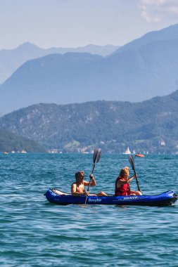 Annecy, Fransa - 21 Ağustos 2008: iki kişi doğa ve dağların muhteşem manzarası ile Annecy Dağı 'nda kano ya da kayıkla geziyor.