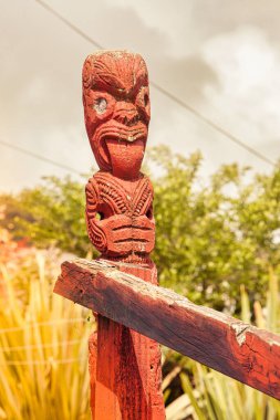 Yeni Zelanda, Rotorua - 28 Eylül 2009: Dilini gösteren bir figürle tahtaya oyulmuş tipik bir maori sanat heykeli
