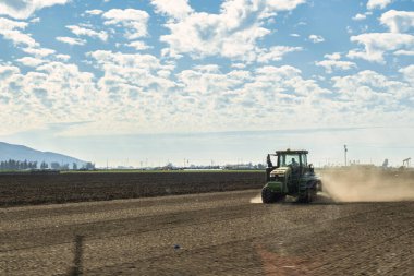 Oxnard, ABD - 21 Şubat: Bir çiftçi tarlayı Oxnard gibi sürmek ve meyve, sebze ve çiçek üretebilmek için bir traktör kullanıyor