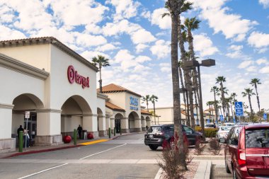 Oxnard, ABD - 21 Şubat: Dükkanları, perakendecileri ve palmiye ağaçlarıyla dolu otoparkı olan tipik bir Amerikan alışveriş merkezi manzarası