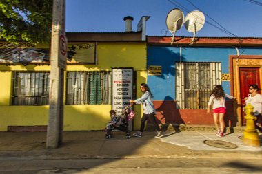 Casablanca, Şili - 17 Kasım 2014: Çok renkli ama küçük Şili evleri ve kaldırımda yürüyen Latin yayalar