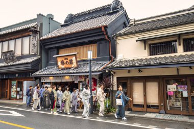 Kawagoe, Japonya - 25 Ekim 2017: Tokyo yakınlarındaki Kawagoe 'de bir yol boyunca edo dönemi tarzında Japon eşya evi binaları ve kimonolu kadınlar