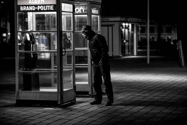 ハーグ オランダ 2009年3月17日 夕方に古い電話ブースを覗き込む男 — ストック写真