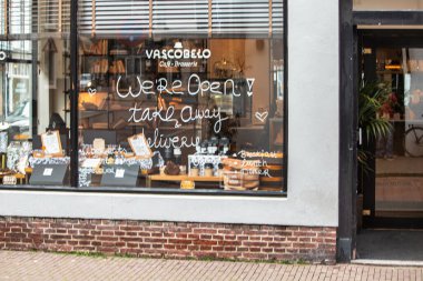 Lahey, Hollanda - 29 Ocak 2021: Lahey 'deki bir restoranın vitrinine teslimat ve paket servisi için açık tabela çizildi