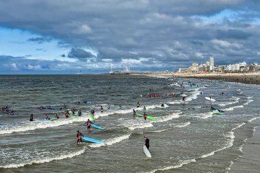 Den Haag, Hollanda - 25 Ağustos 2021: Scheveningen Denizi 'nde sörf dersleri alan birçok genç ve izleyen diğer insanlar