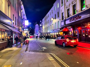 Londra, Birleşik Krallık - 6 Mart 2022: kulüplerin gece hayatı restoranı ve barları ile canlı bir Soho sokağı.