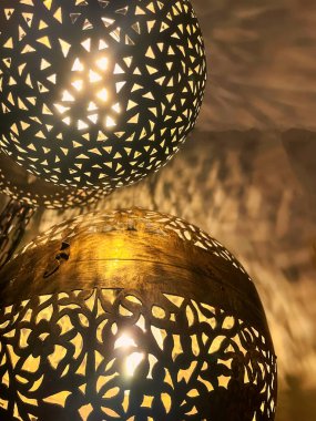 Duvarda birkaç tipik bakır İran ya da Morroka lambalarının yansımaları görülebilir.