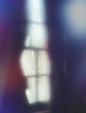 Çok renkli perdelerle pencere çerçevesinin bulanık ve gizemli görünümü