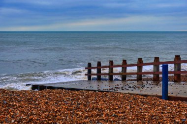 Bognor regis, Birleşik Krallık - Mart 04 2022 İngiliz sahil beldesinde bir çakıl taşı plajı ve beton yürüyüş yolu