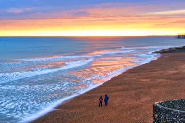 英国布莱顿 2022年3月4日 人们在海滩上散步 看到水面上的落日倒影 — 图库照片