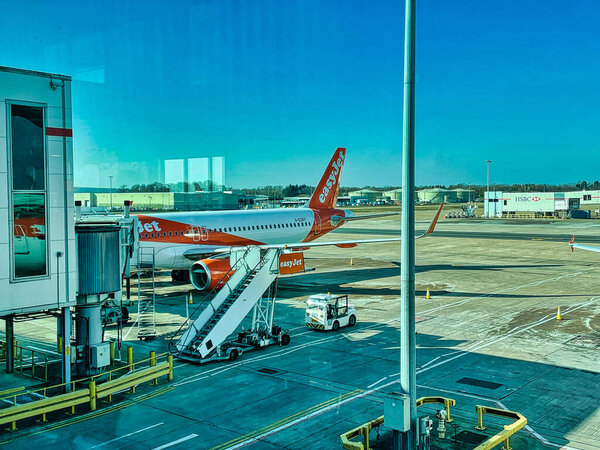 London, United Kingdom - March 07 2022: a british low cost carrier is docked to the terminal on an airport waiting for boarding passengers
